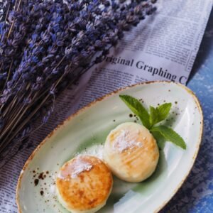 Aesthetic dessert scene showcasing pancakes on a green plate with lavender and mint garnishing.