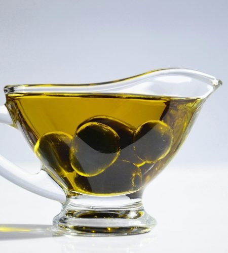 About High-resolution image of a glass cup filled with olive oil and olives, ideal for culinary themes, oil morocco, olives.
